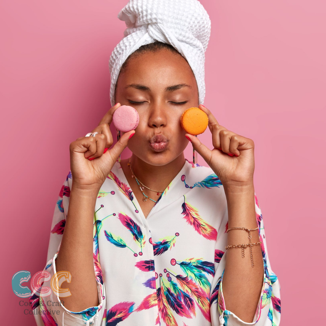 Ever wanted to learn how to make perfect French macarons from home? Well now you can buy your own DIY activity kit and perfect the tastiest macaron. IMage shows a woman holding two macarons up to her cheeks and pouting.