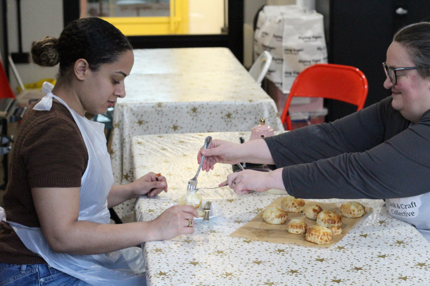Adding a dollop of clotted cream to a scone.
