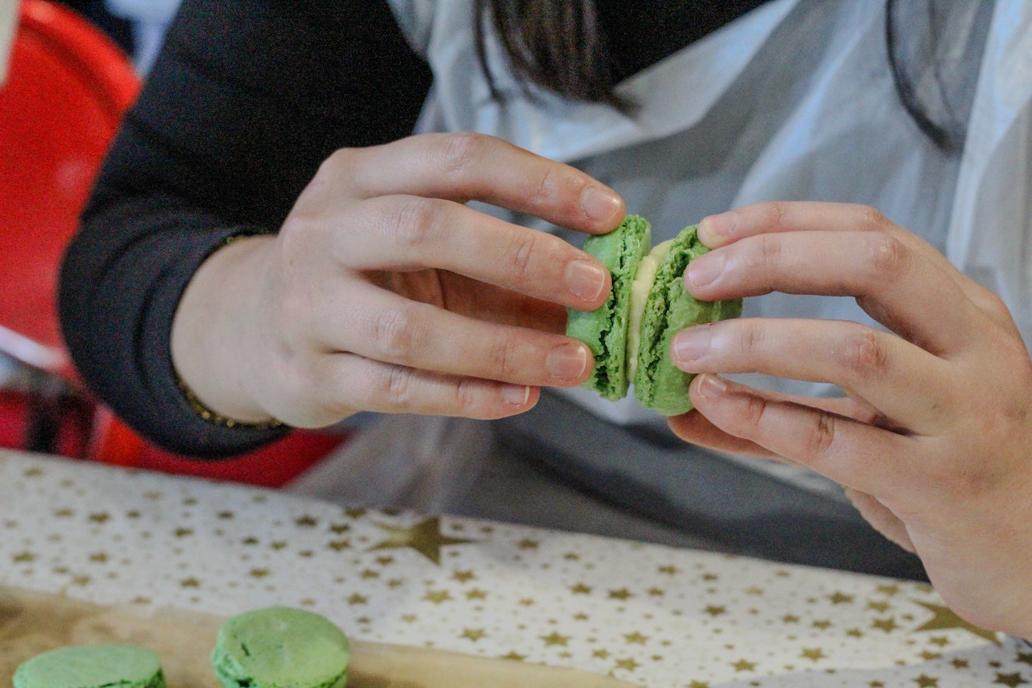 A green macaron is assembled