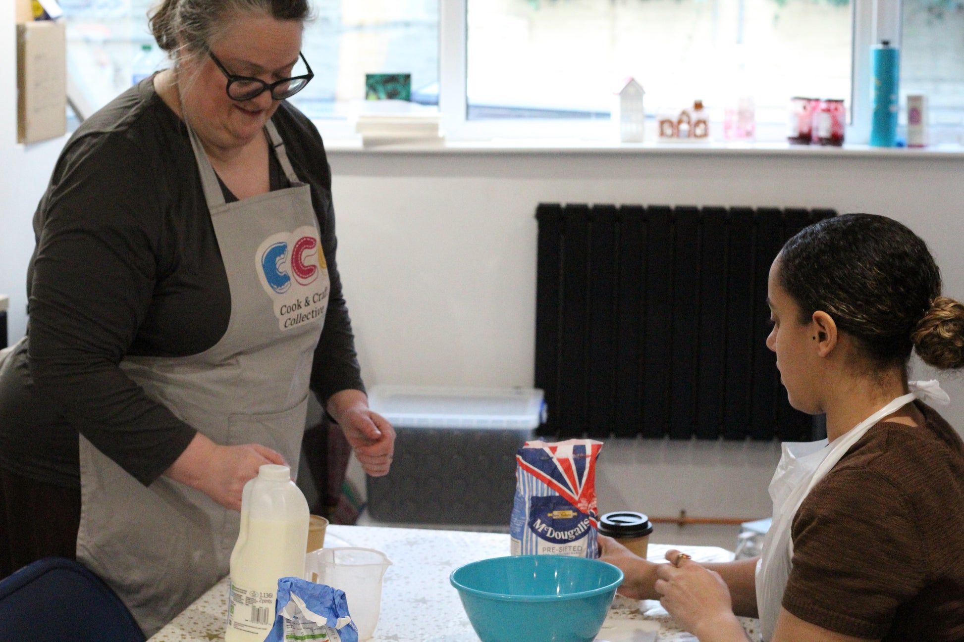 Course leader Joanne talks a woman through the dough-making process.