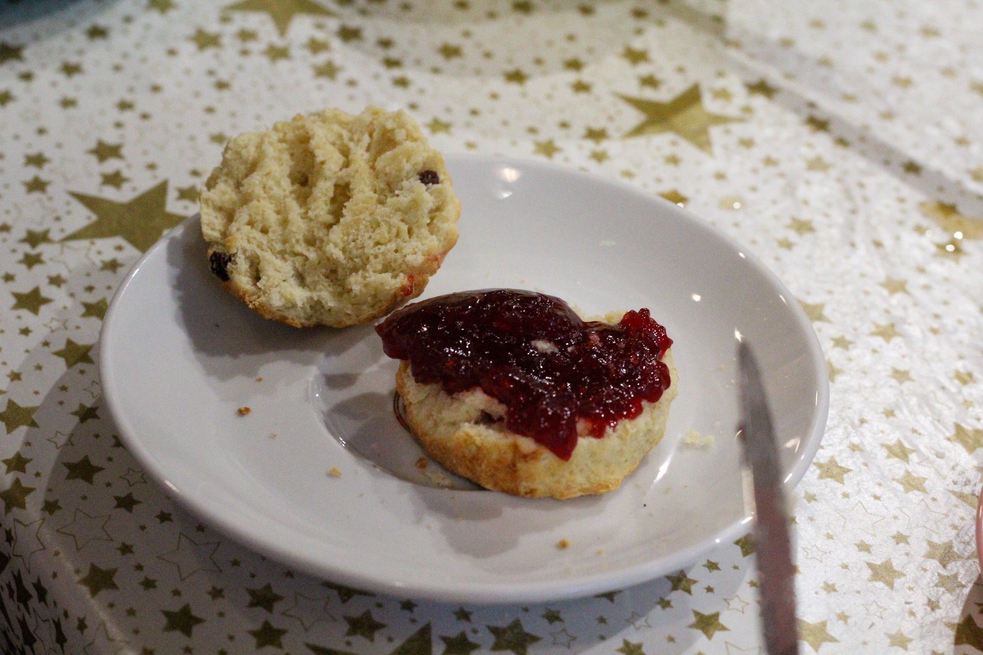 A split scone with jam on it. 