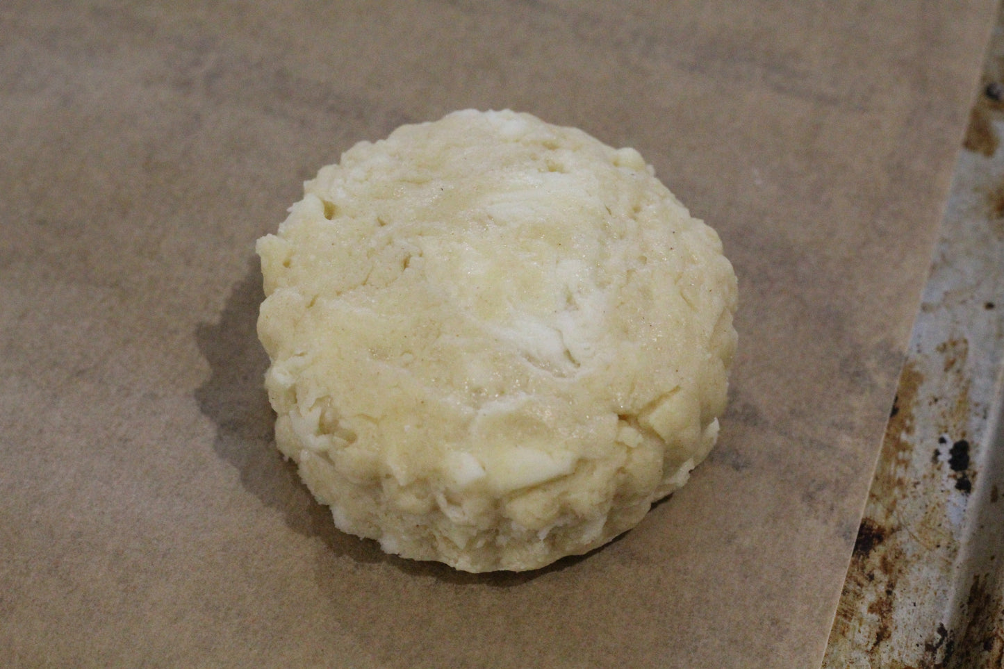 Close up of a scone on a baking sheet ready to go into the oven.