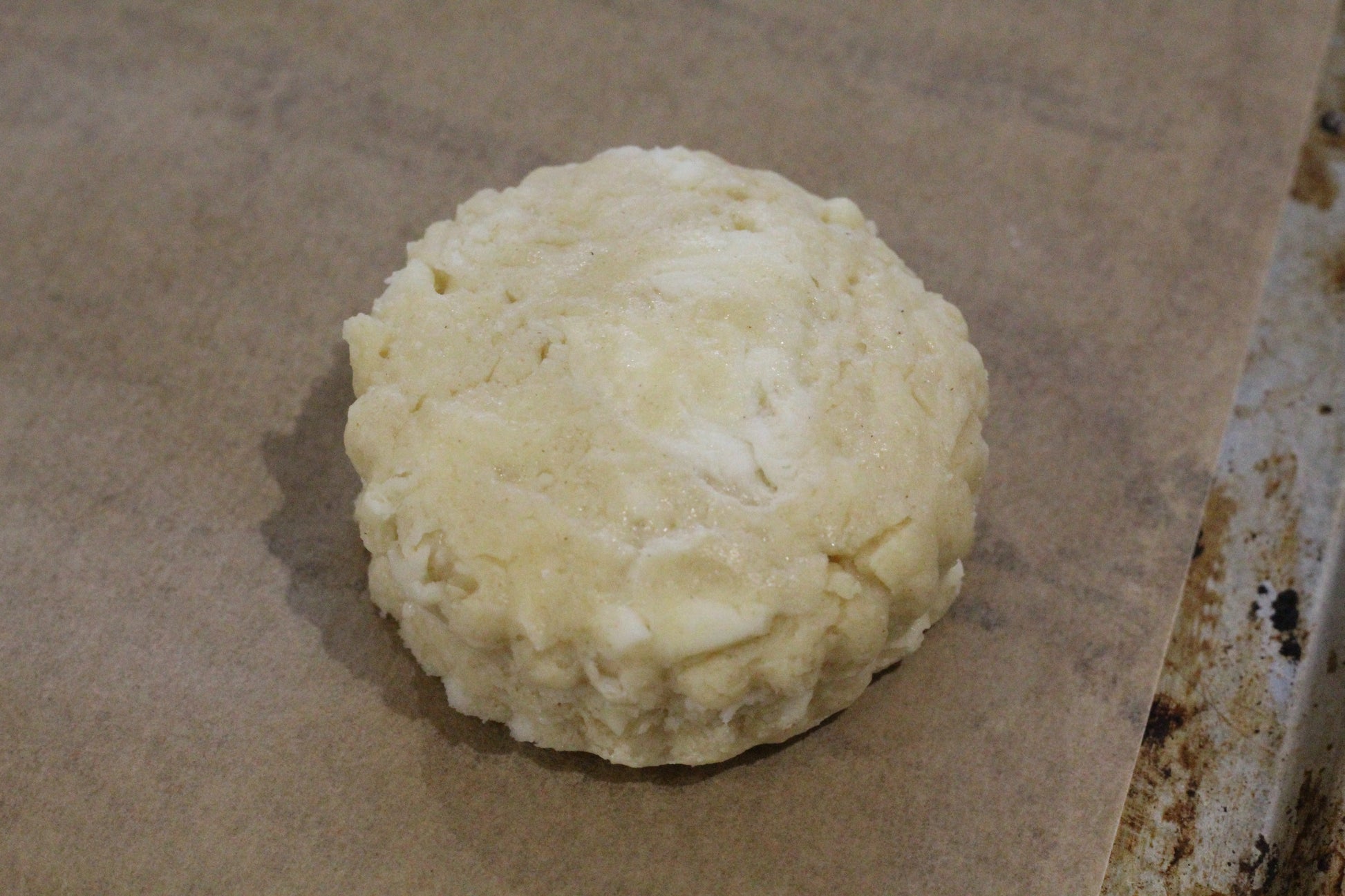 Close up of a scone on a baking sheet ready to go into the oven.