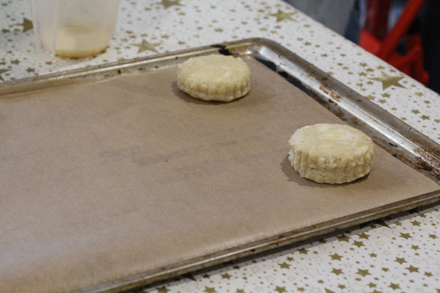 Two scones sit on a baking tray, ready for baking.