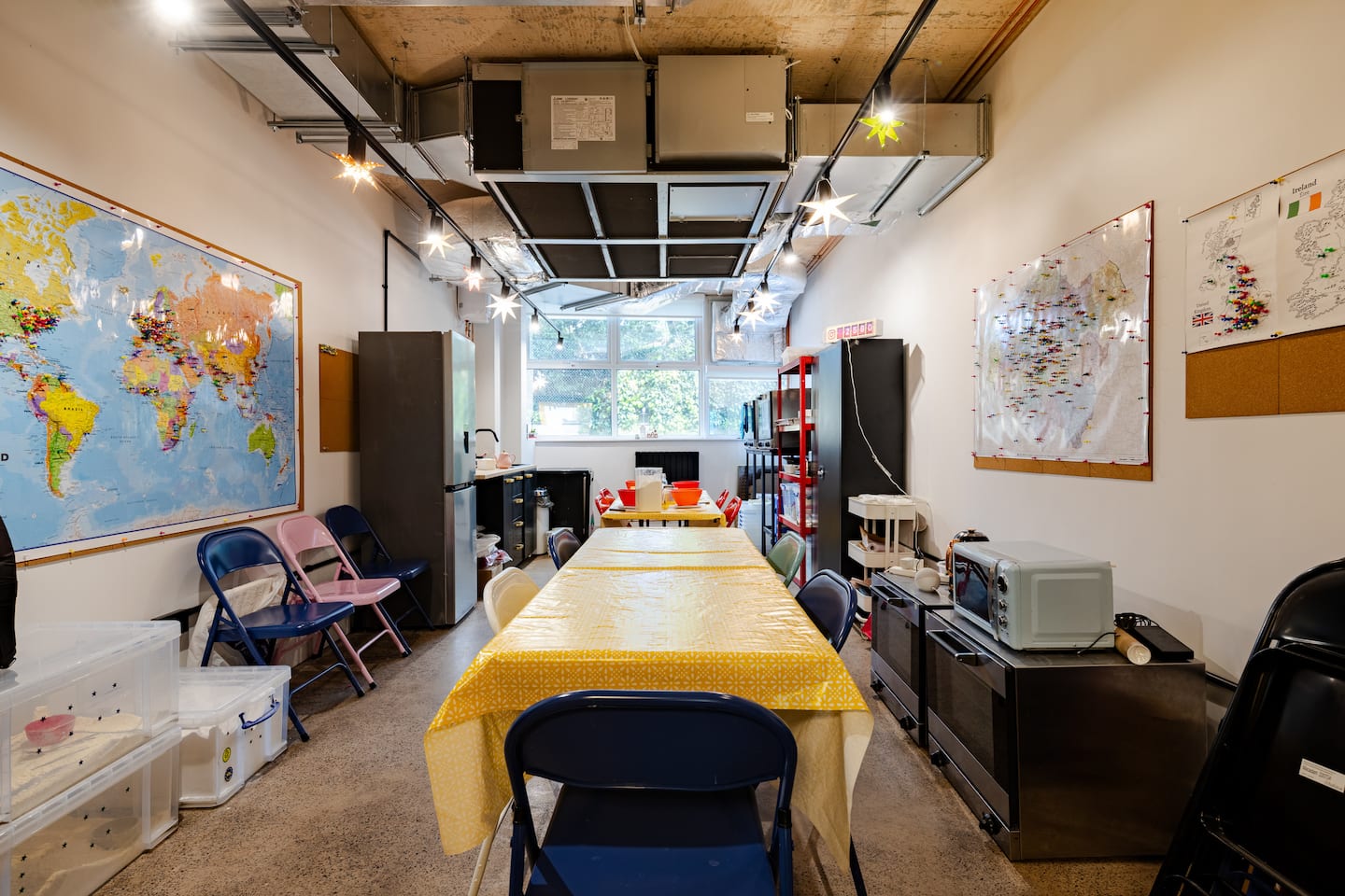 Room with a table, chairs, and world map on the wall