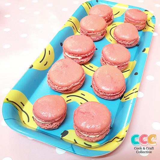 Come and experience a Parisian adventure at your fabulous hen party, pour yourself a tipple and learn how to make delicious French macarons.  Image shows delicious pink French Macarons on a tray with bananas on.