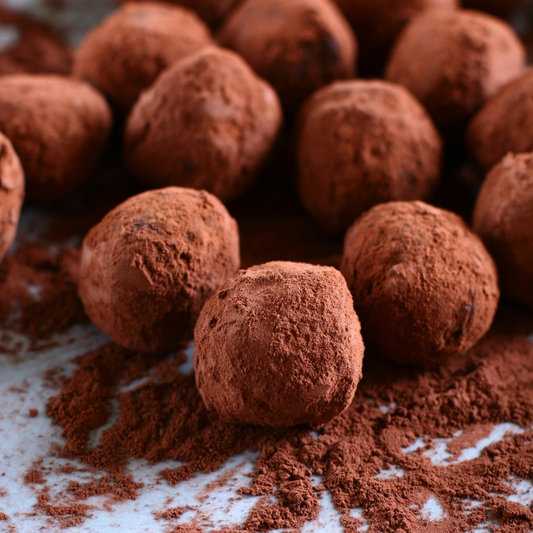 Create creamy chocolate truffles and become a truffle-maker with Cook and Craft Collective. Image shows a close up of chocolate truffles dusted with coco