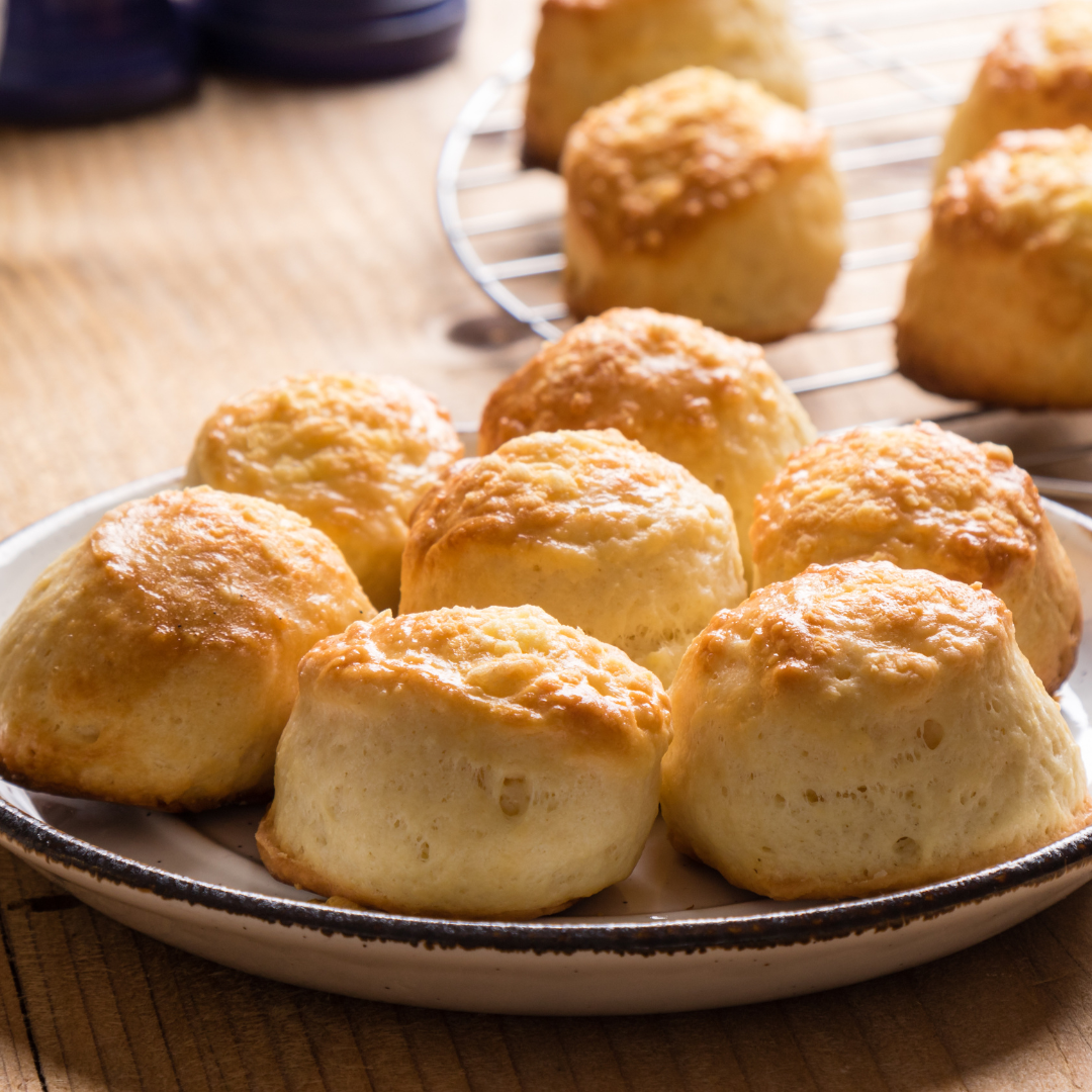 Learn to make delicious scones like these fluffy ones presented on a plate with Cook and Craft Collective